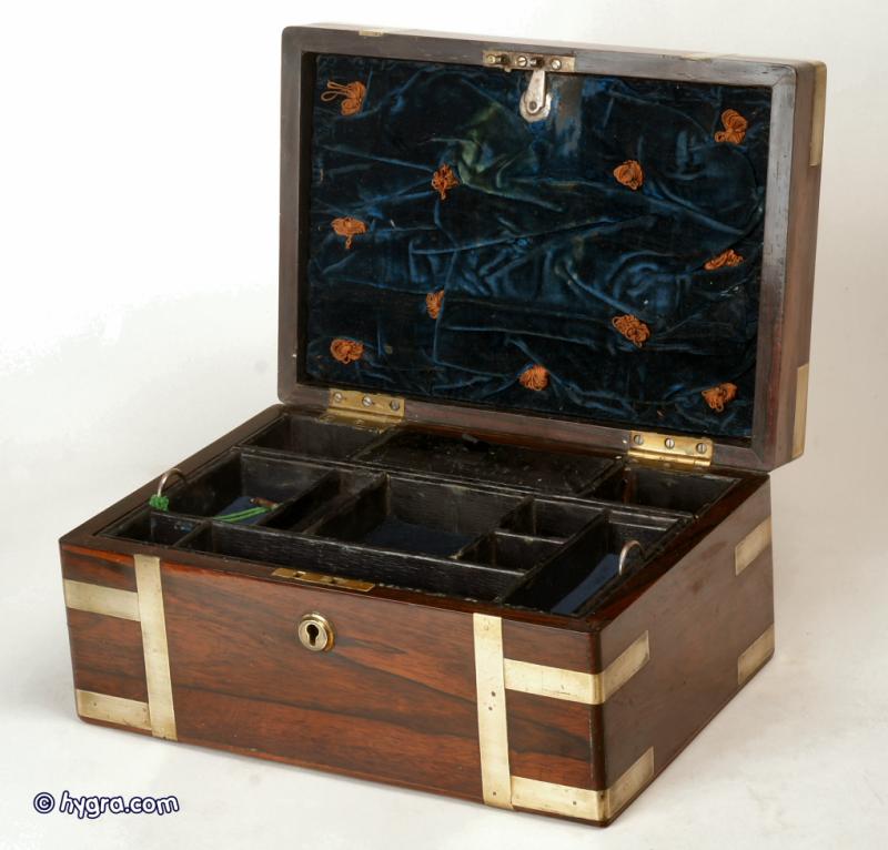 JB216: A Regency figured rosewood box with rounded edges, all brassbound, with liftout tray, document wallet, and mirror; the box having a countersunk carrying handle to the top,  and working lock and key. circa 1830. Enlarge Picture